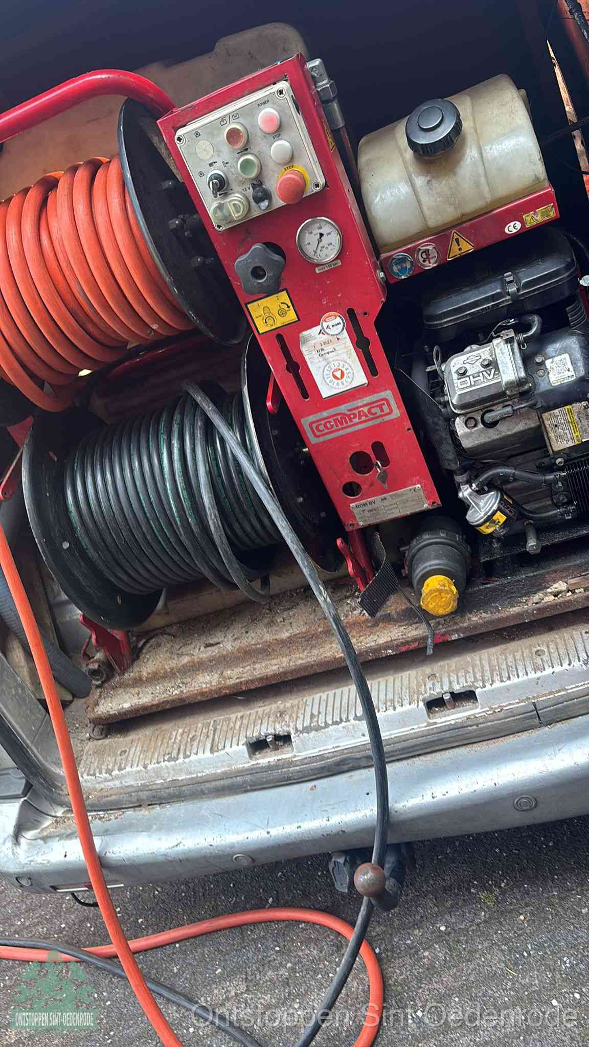 Een rood hogedruk-rioolreinigingstoestel in de laadbak van de bedrijfsbus, apparatuur voor een hardnekkige afvoerverstopping in Sint Oedenrode