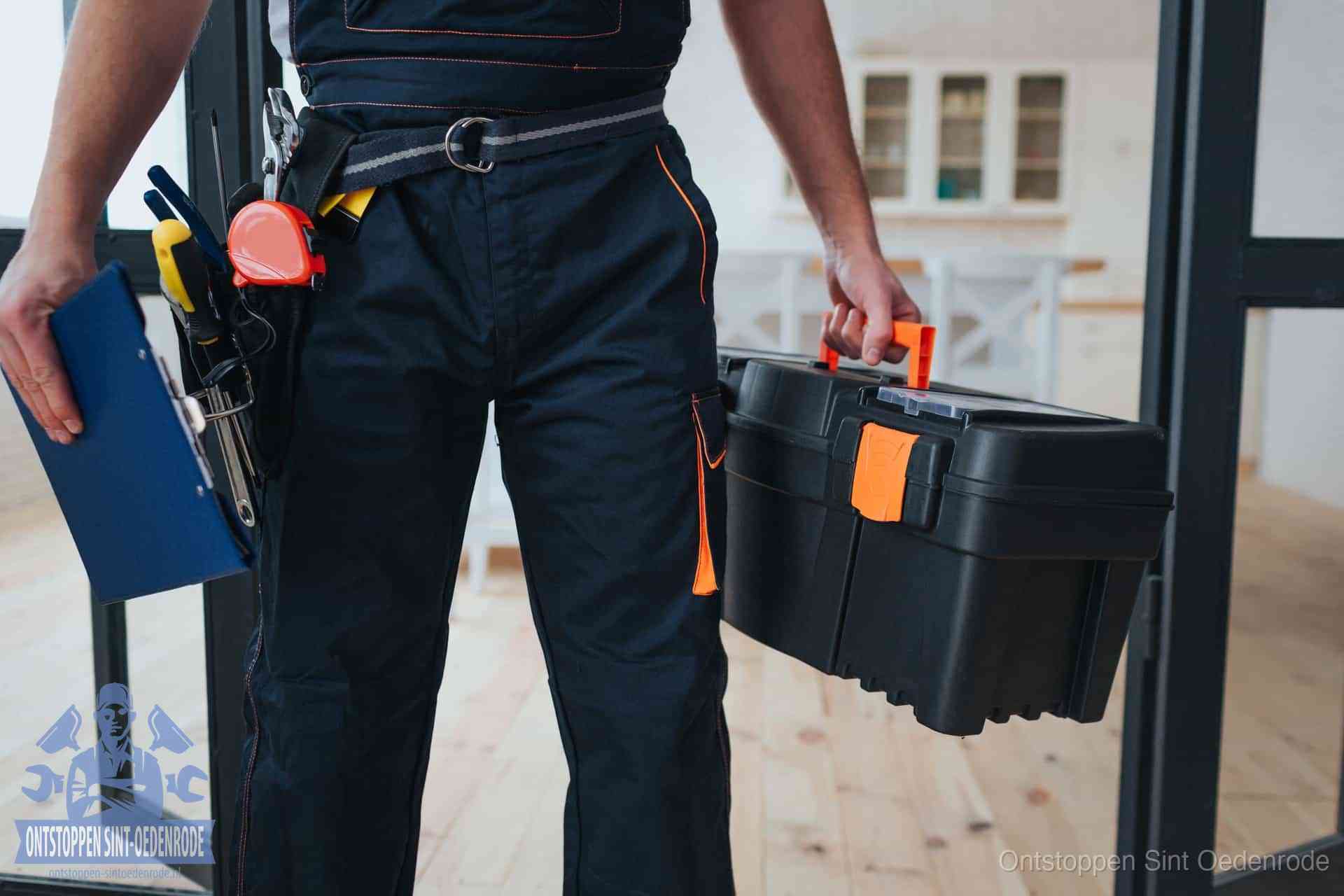 Een monteur met gereedschapsriem en klembord in een keuken, klaar om een transparante prijs voor het gootsteen ontstoppen in Sint Oedenrode te geven