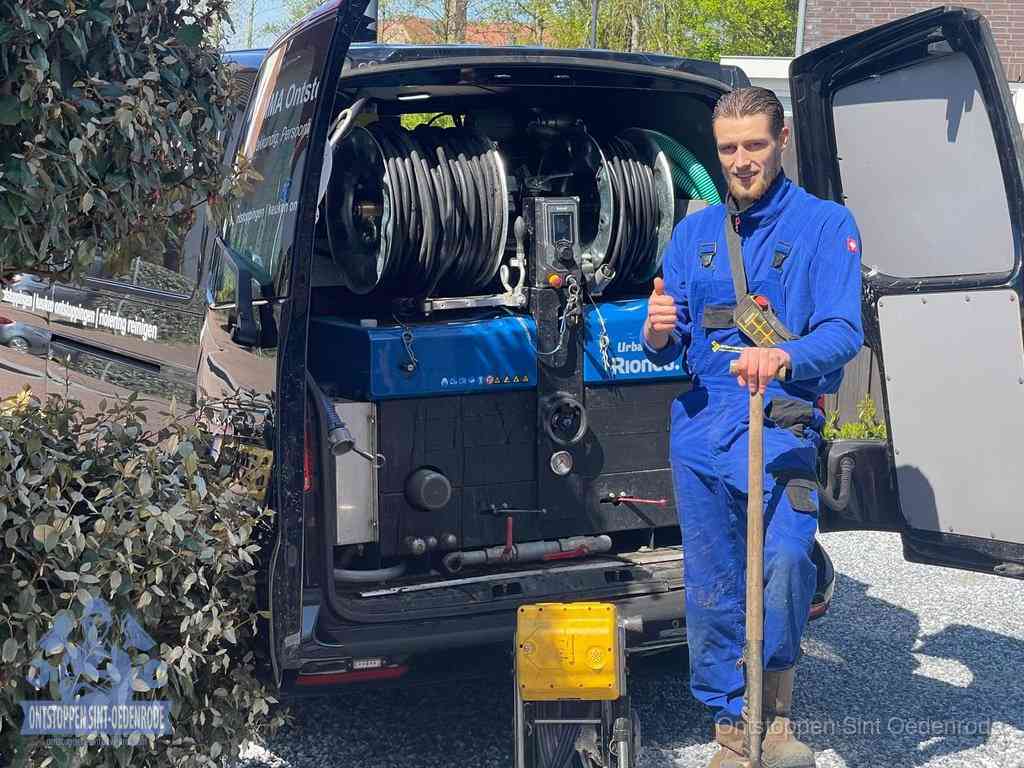 Professioneel rioolontstoppingsbedrijf in Sint Oedenrode Lachende monteur bij de volle rioolreinigingsbus, een professioneel rioolontstoppingsbedrijf in Sint Oedenrode