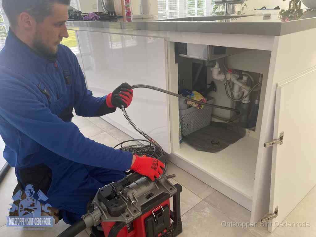 Een monteur reinigt de keukenafvoer grondig met een veermachine om terugkerende gootsteenverstoppingen te voorkomen in Sint Oedenrode