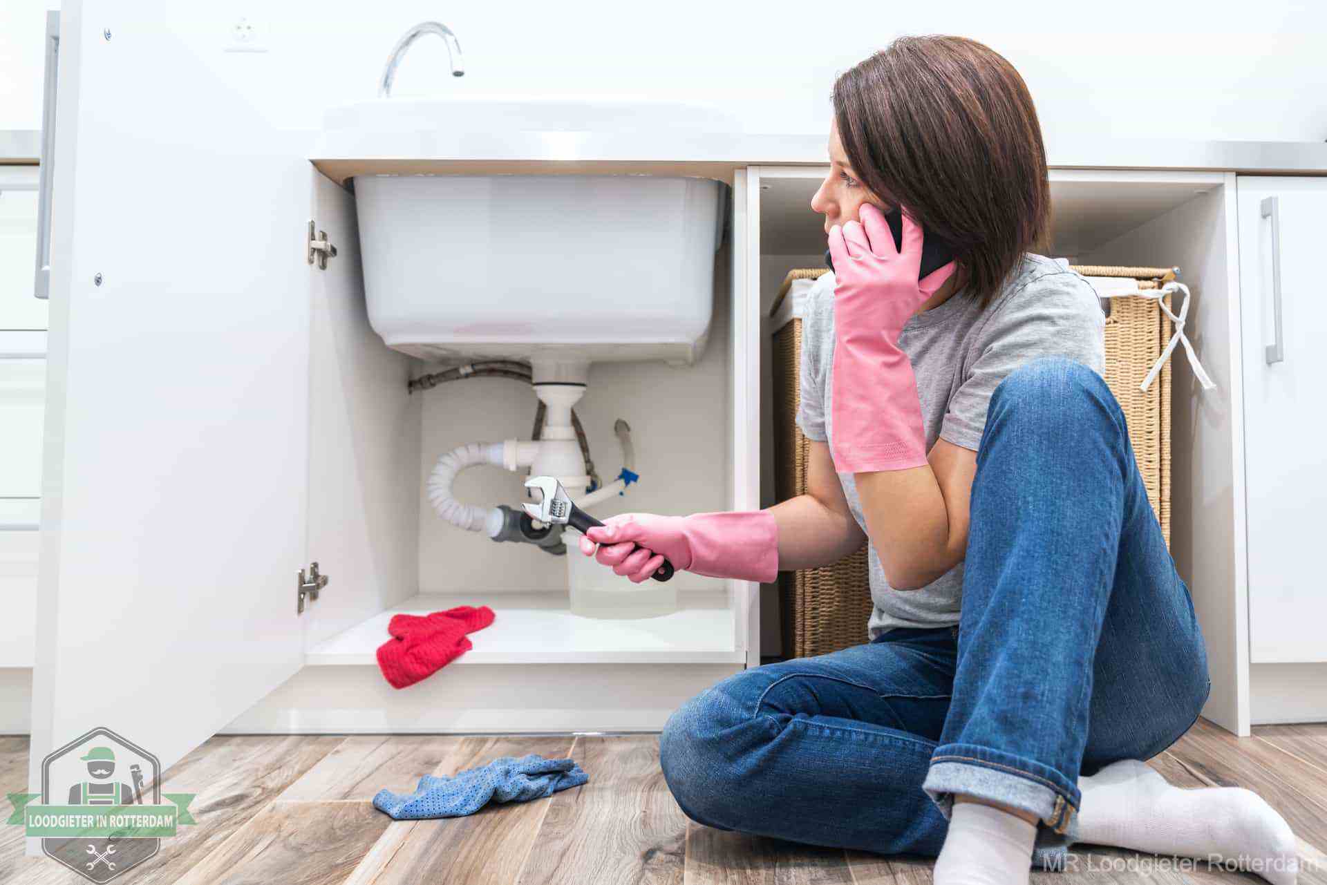 Een hand strooit met een lepel soda in een afvoerputje, de soda en azijn huismiddel-methode om de wc te ontstoppen in Sint Oedenrode