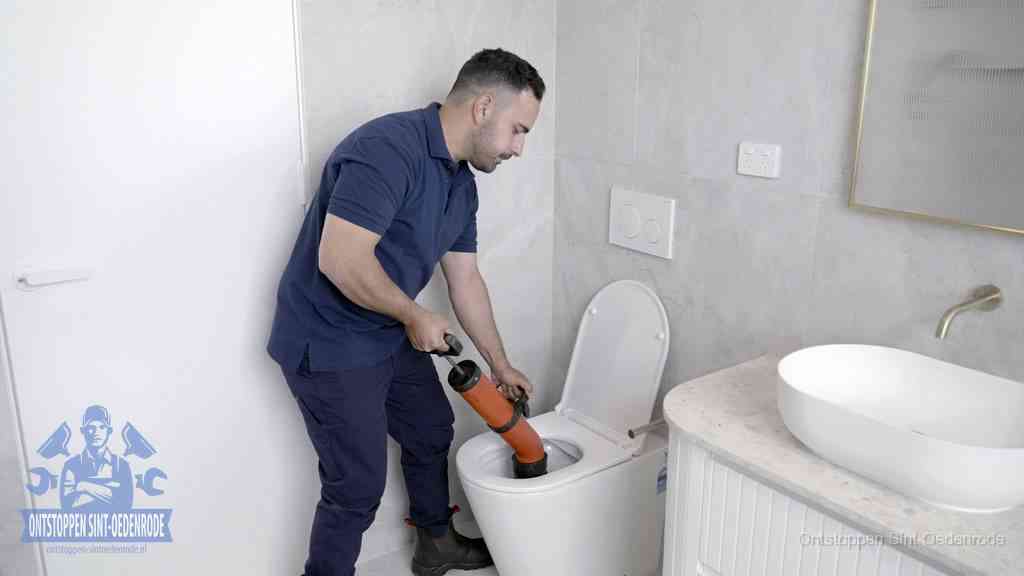 Een monteur gebruikt een handmatige perspomp (toiletontstopper) op een wandcloset tijdens het professioneel wc ontstoppen in Sint Oedenrode
